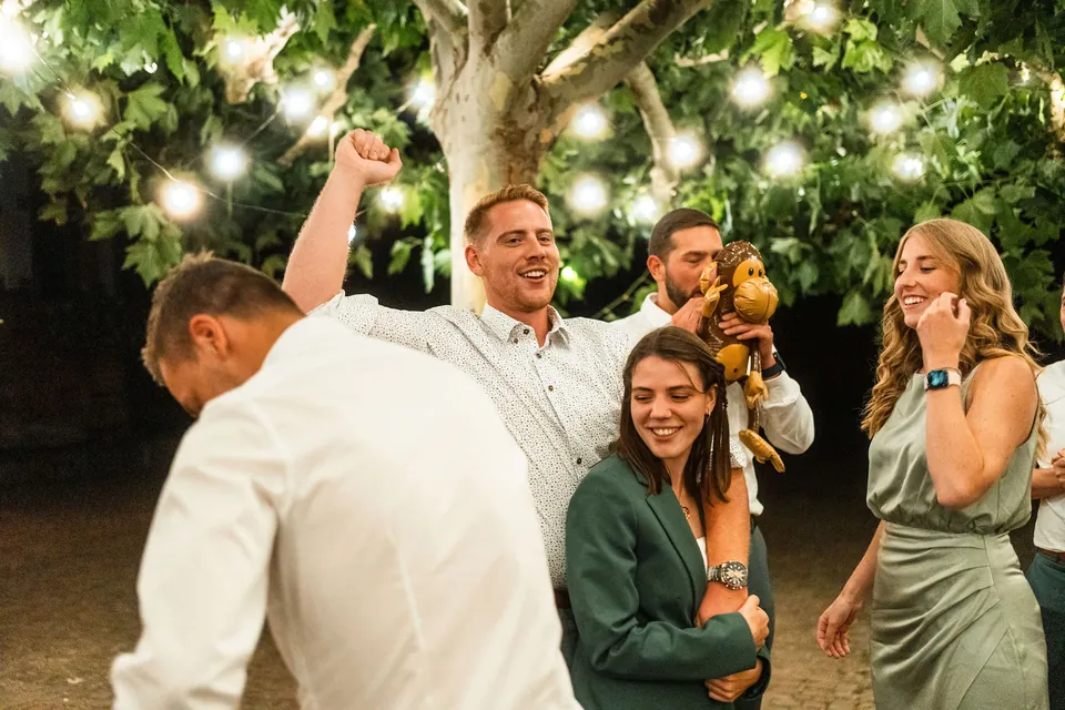 Gäste jubeln unter Lichterketten im Garten, Hochzeit auf dem Schlossgut Lüll