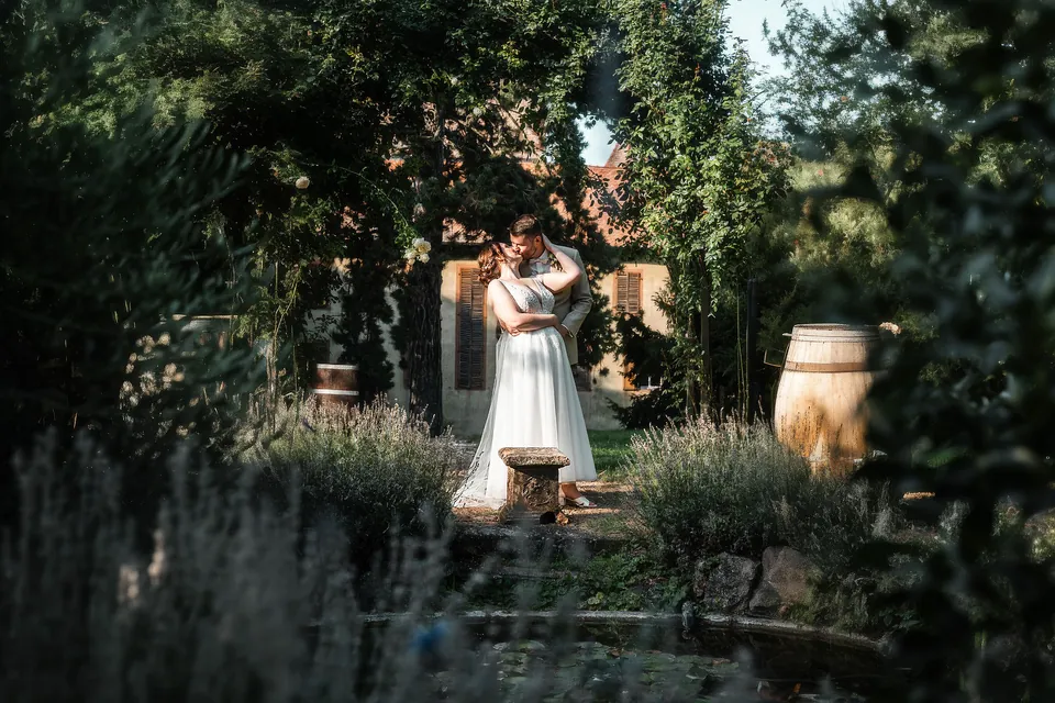 Brautpaar im verwunschenen Garten zwischen Lavendel und Weinfässern, Hochzeit auf dem Schlossgut Lüll
