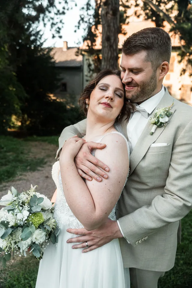Braut lacht im Arm des Bräutigams, Hochzeit auf dem Schlossgut Lüll