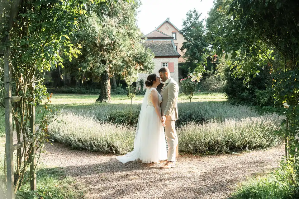 Brautpaar auf dem Gartenweg unter Bäumen, Hochzeit auf dem Schlossgut Lüll
