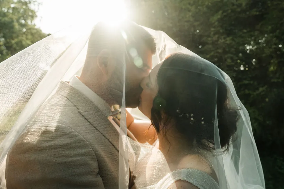Kuss unter dem Schleier im Gegenlicht, Hochzeit auf dem Schlossgut Lüll