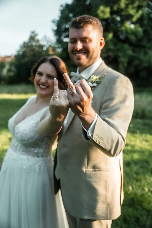 Brautpaar zeigt lachend die Eheringe, Hochzeit auf dem Schlossgut Lüll