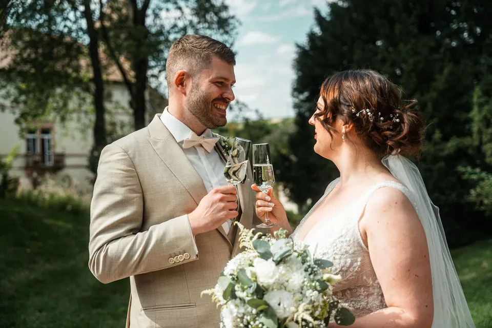 Brautpaar stößt mit Sektgläsern an, Hochzeit auf dem Schlossgut Lüll