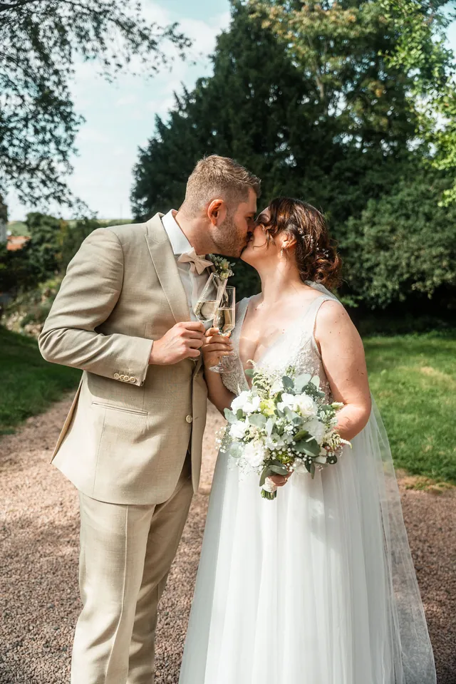 Kuss beim Sektempfang, Hochzeit auf dem Schlossgut Lüll