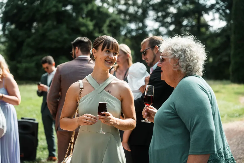 Gäste mit Weingläsern beim Empfang, Hochzeit auf dem Schlossgut Lüll