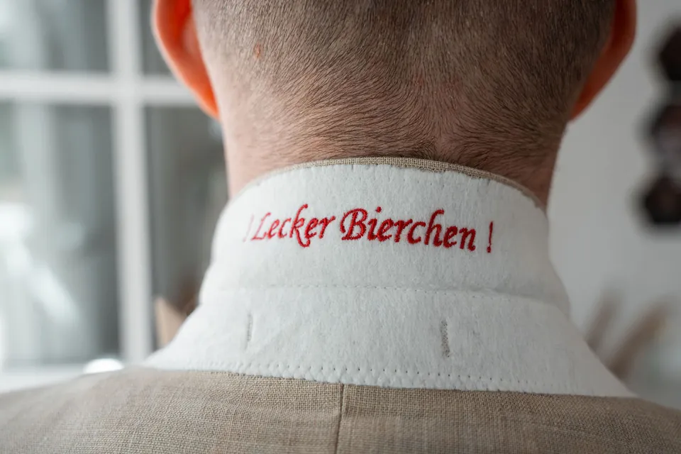 Lecker Bierchen in den Hemdkragen des Bräutigams gestickt, Hochzeit auf dem Schlossgut Lüll