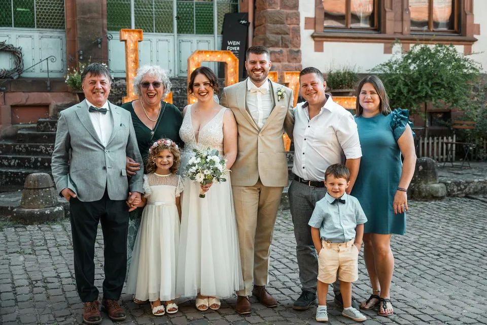 Familienfoto vor dem Sandsteingebäude, Hochzeit auf dem Schlossgut Lüll