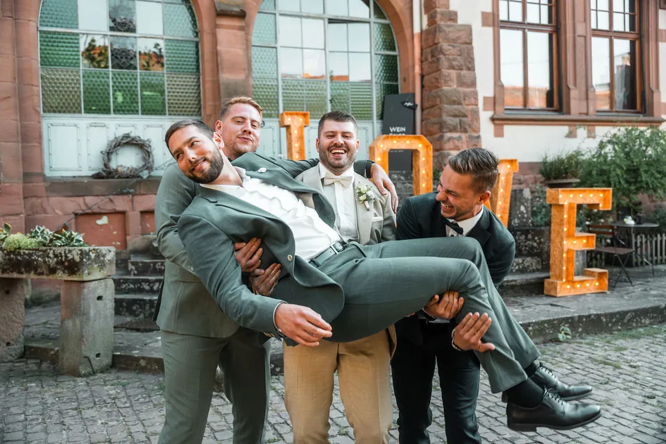 Freunde tragen den Bräutigam waagerecht, Hochzeit auf dem Schlossgut Lüll