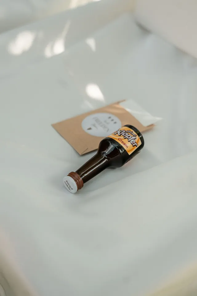 Kleines Bierfläschchen als Gastgeschenk auf dem Stuhl, Hochzeit auf dem Schlossgut Lüll