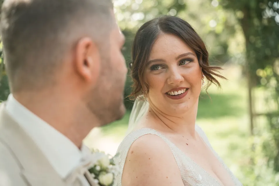 Brautpaar sieht sich lächelnd an, Hochzeit auf dem Schlossgut Lüll
