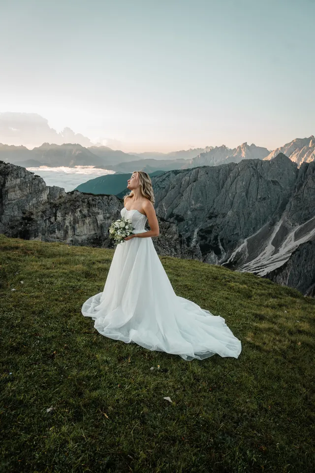 Braut mit langer Schleppe am Abgrund, After-Wedding-Shooting in den Dolomiten