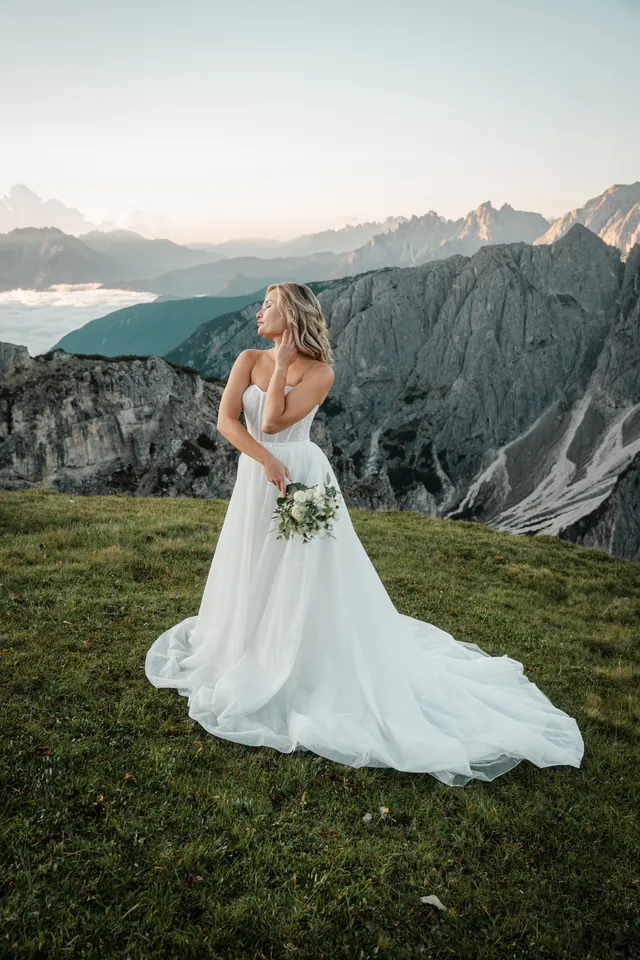 Braut blickt über die Schulter ins Tal, After-Wedding-Shooting in den Dolomiten
