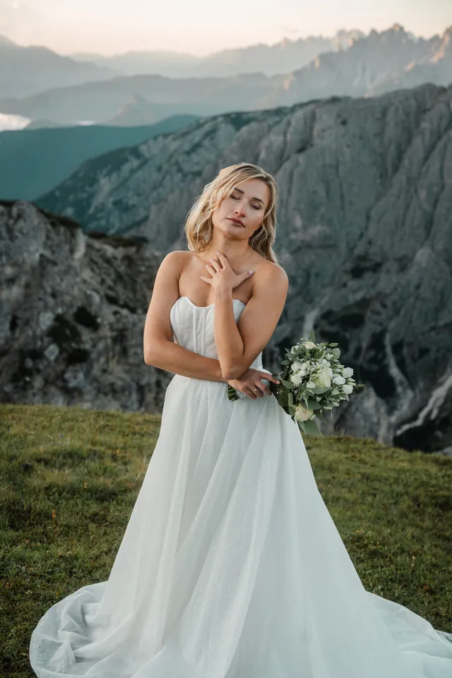 Braut mit Brautstrauß vor den Felswänden, After-Wedding-Shooting in den Dolomiten
