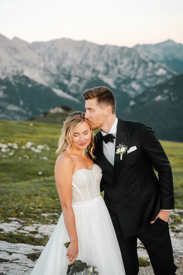 Bräutigam küsst die Braut auf die Stirn, After-Wedding-Shooting in den Dolomiten