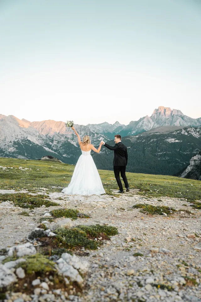 Braut zieht den Bräutigam über die Alm, After-Wedding-Shooting in den Dolomiten