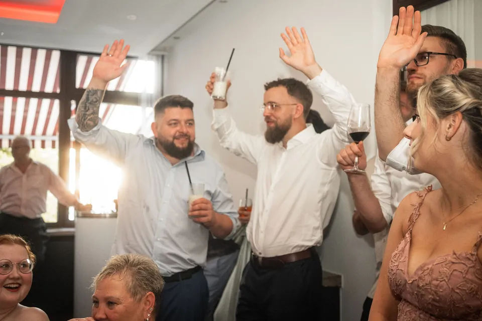 Gäste jubeln mit erhobenen Armen, Hochzeit im Moods
