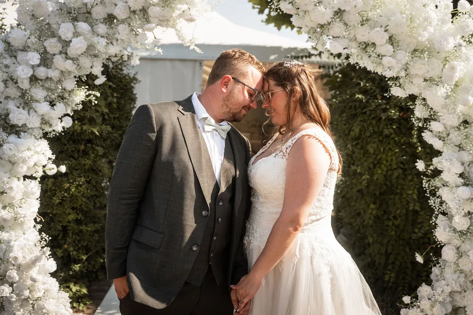Brautpaar im weißen Blumenbogen, Hochzeit im Moods