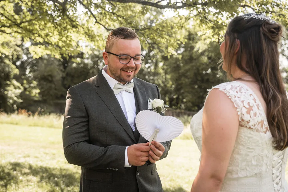 Bräutigam liest einen Brief mit Papierherz, Hochzeit im Moods