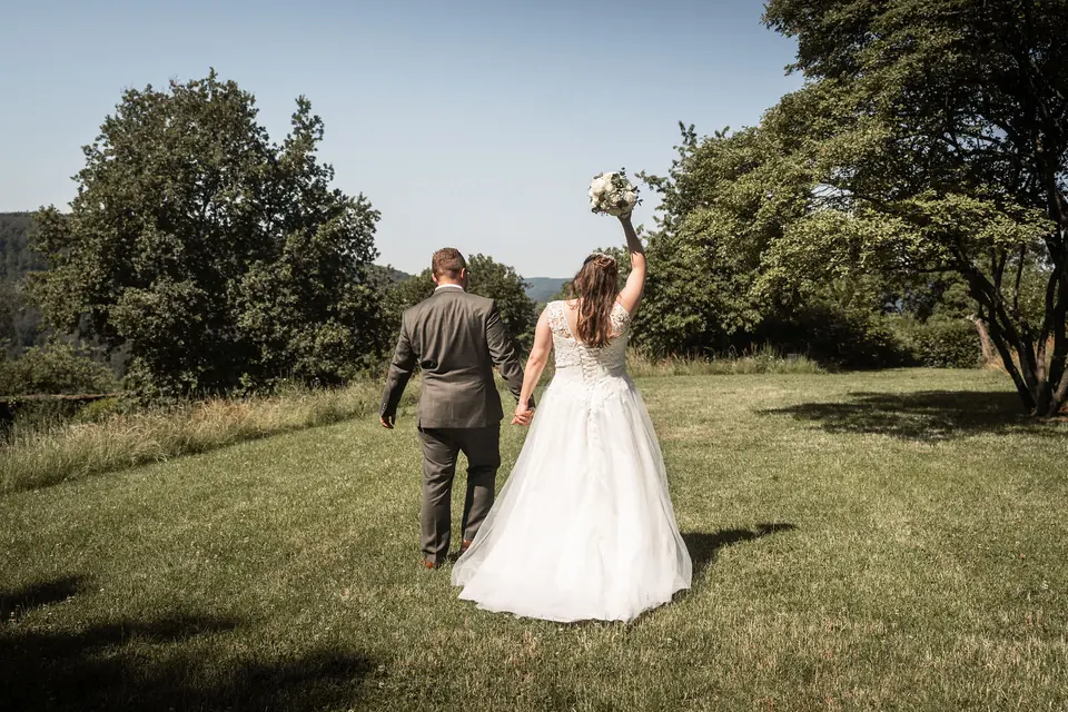 Brautpaar läuft über die Wiese, Hochzeit im Moods