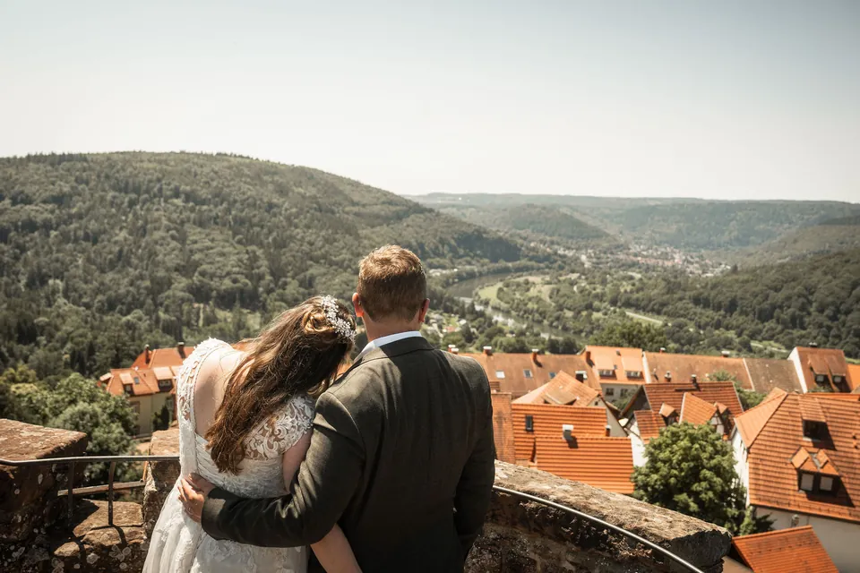 Brautpaar blickt über die Dächer ins Tal, Hochzeit im Moods