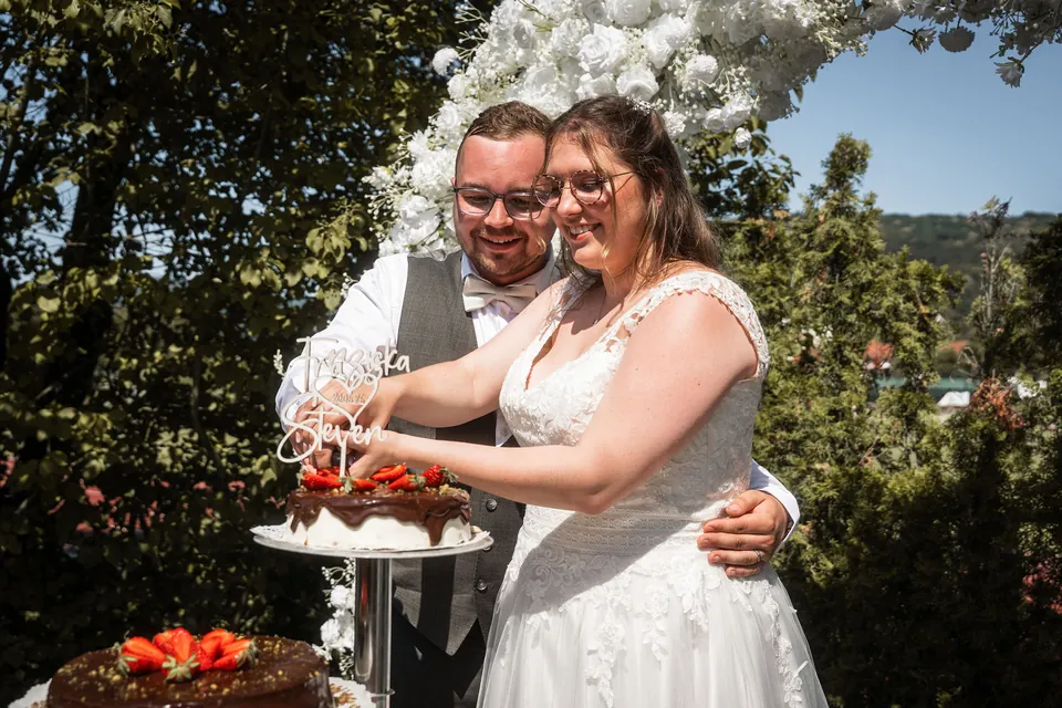 Tortenanschnitt im Blumenbogen, Hochzeit im Moods