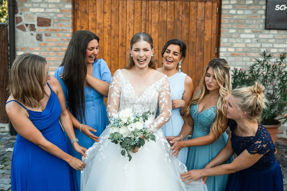 Braut lacht mit ihren Freundinnen, Hochzeit in der Schleifenmühle Dettenheim-Rußheim