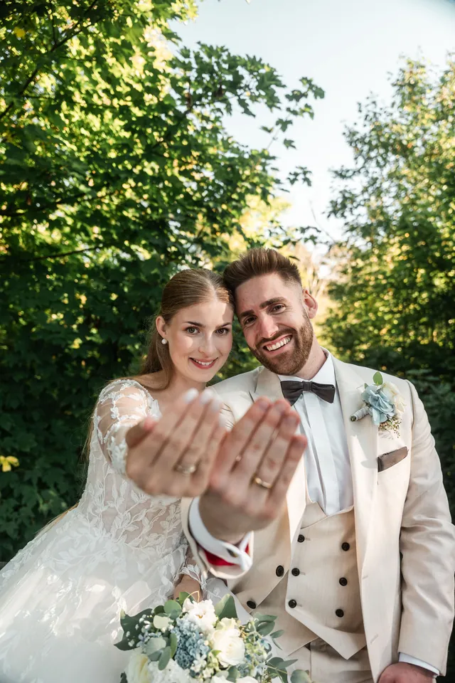 Melanie und Robin halten ihre Ringfinger in die Kamera, Hochzeit in der Schleifenmühle Dettenheim-Rußheim bei Karlsruhe