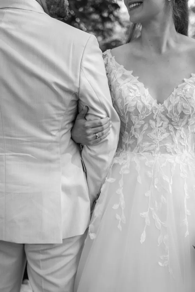 Melanie hakt sich bei Robin unter, Detail in Schwarz-Weiß, Hochzeit in der Schleifenmühle Dettenheim-Rußheim bei Karlsruhe