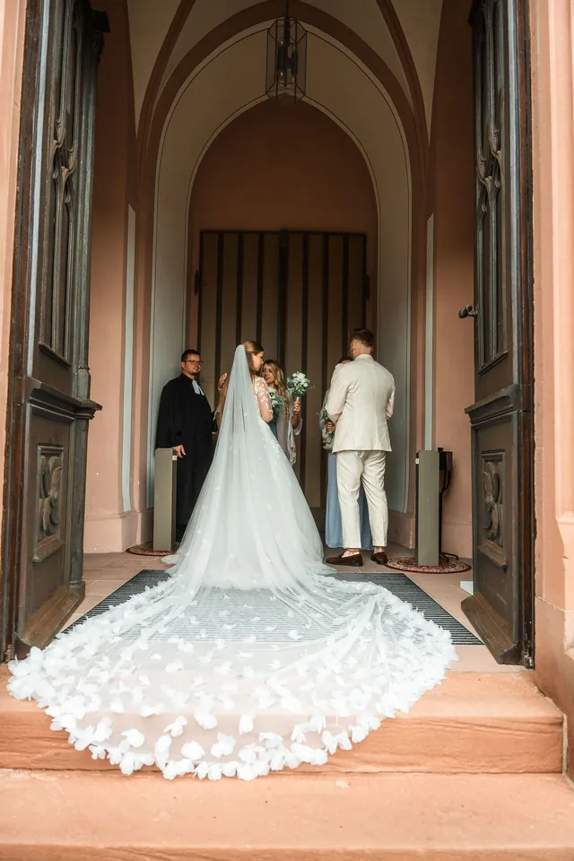 Braut mit langer Schleppe am Kircheneingang, Hochzeit in der Schleifenmühle Dettenheim-Rußheim