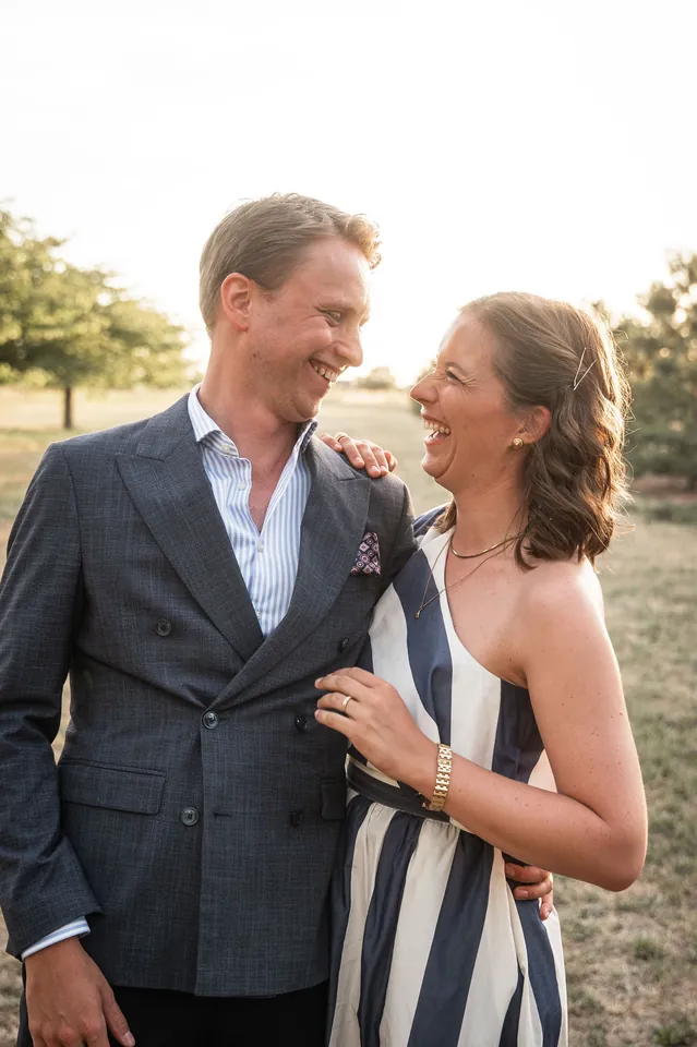 Befreundetes Paar lacht sich im Abendlicht auf dem Feld an, Hochzeit im Eichenstolz Ladenburg