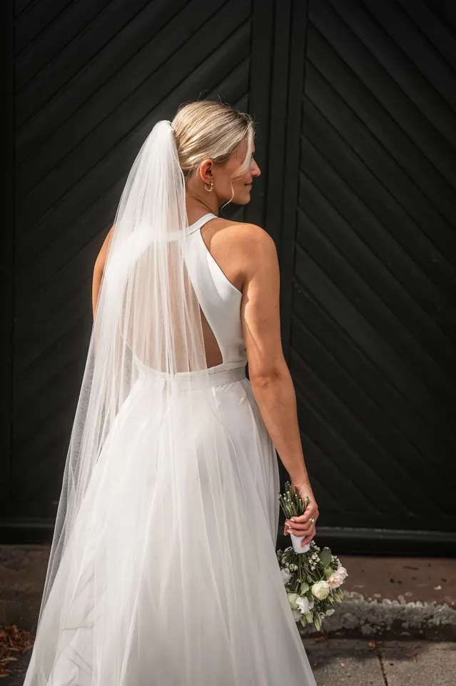Braut mit langem Schleier vor dunklem Tor, Hochzeit im Eichenstolz Ladenburg