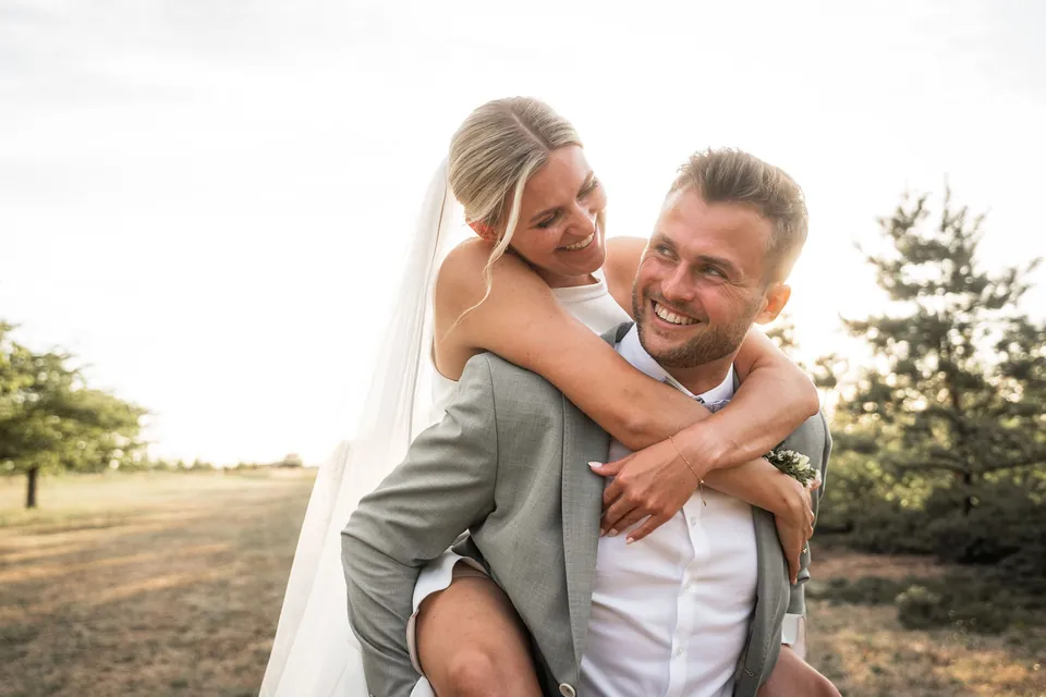 Bräutigam trägt die lachende Braut huckepack, Hochzeit im Eichenstolz Ladenburg