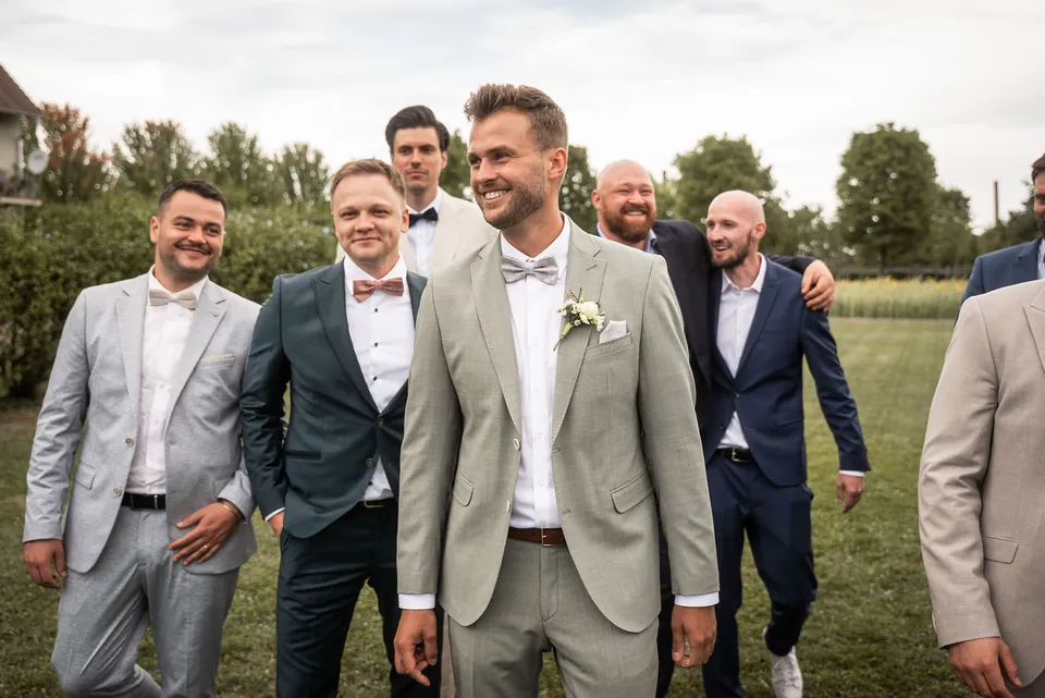 Bräutigam läuft lachend mit seinen Freunden über die Wiese, Hochzeit im Eichenstolz Ladenburg