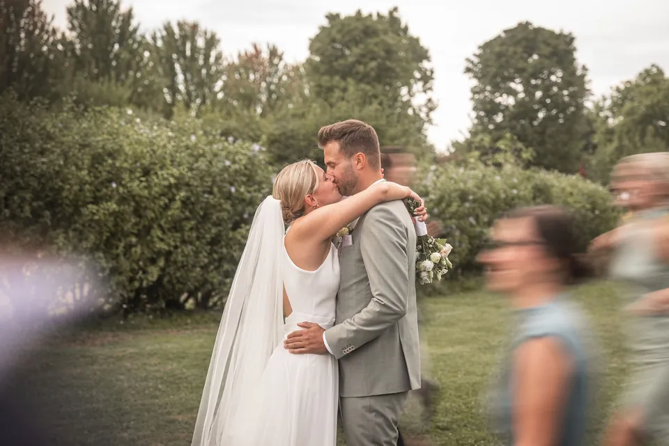 Gäste rennen lachend um das küssende Brautpaar, Hochzeit im Eichenstolz Ladenburg