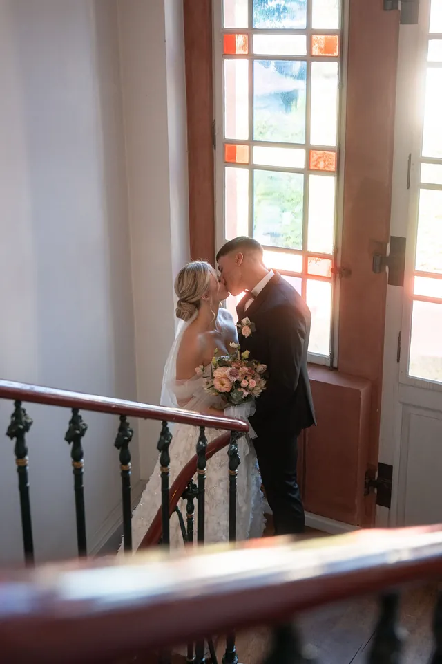 Kuss am bunten Fenster im Treppenhaus des Standesamts, Hochzeit am Schloss Schwetzingen