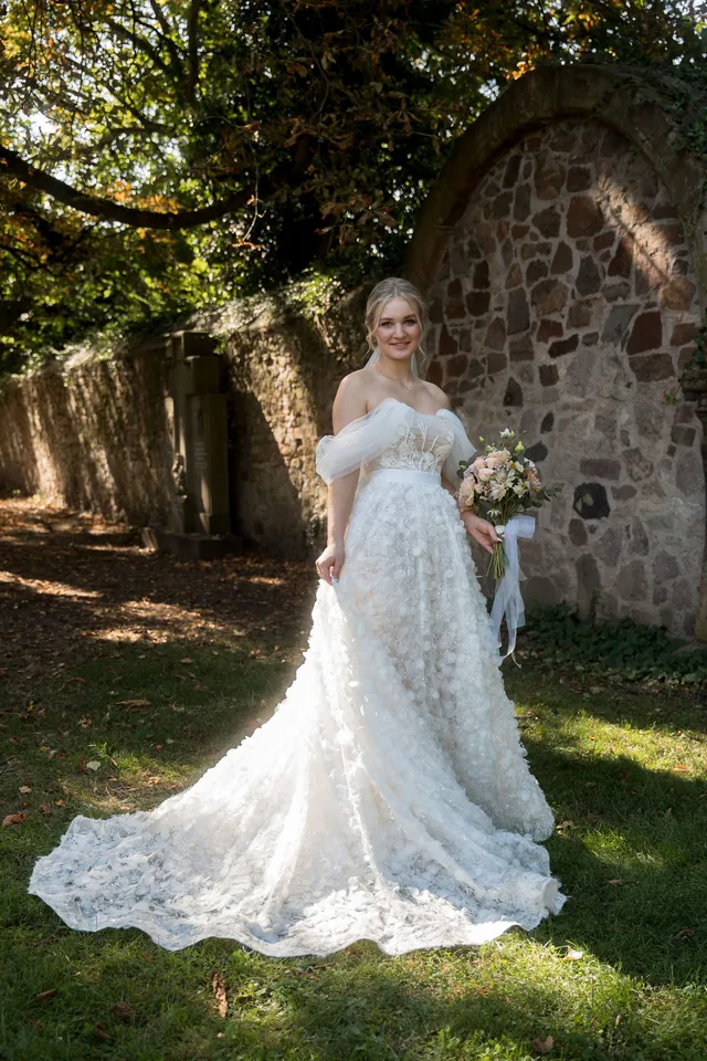 Braut mit langer Schleppe vor der Steinmauer, Hochzeit am Schloss Schwetzingen