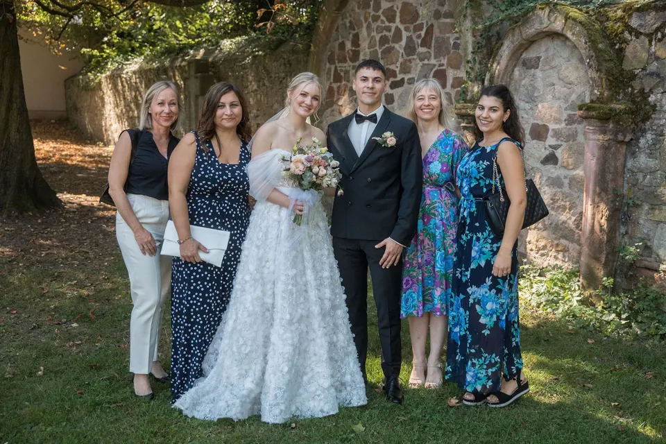 Brautpaar mit Freundinnen vor der Steinmauer, Hochzeit am Schloss Schwetzingen