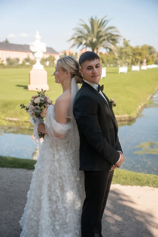 Brautpaar Rücken an Rücken vor Palmen, Hochzeit am Schloss Schwetzingen