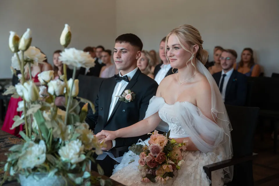 Brautpaar sitzt nebeneinander im Trauzimmer, Hochzeit am Schloss Schwetzingen